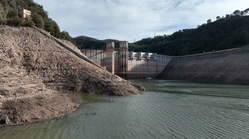 Extreme low water levels at dam reservoir during drought season, aerial view