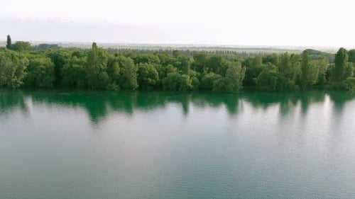 Aerial view of water reservoir with green trees