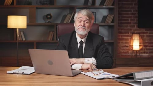 Greyhaired Employee Raising Hand in Yes Gesture in Office