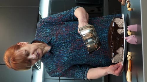 Person Pours Chocolate Sauce Over Loaf in Kitchen