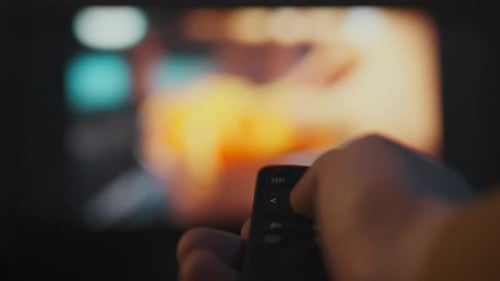 Hand Operating Television Remote Control at Night