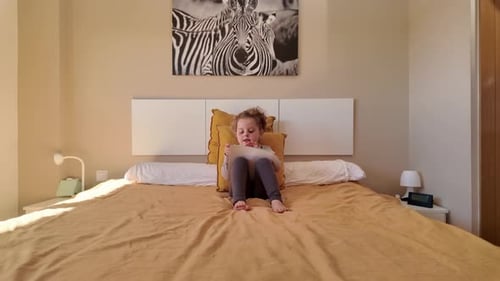Little Girl Reading a Book on Bed