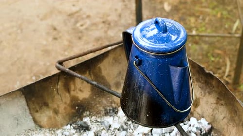 Blue percolator coffee pot steams on fire - removing lid reveals spewing coffee