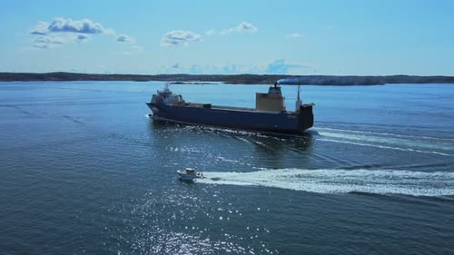 Speedboat And Cargo Ship Sailing In The Ocean Near Lysekil In Bohuslan, Sweden. - aerial