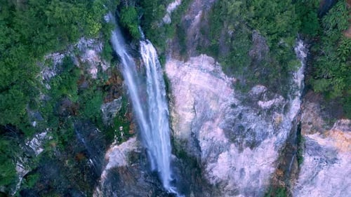 Blick aus der Vogelperspektive: Grüne Natur des Waldes, Wasserfall und feuchter Berg im Fluss