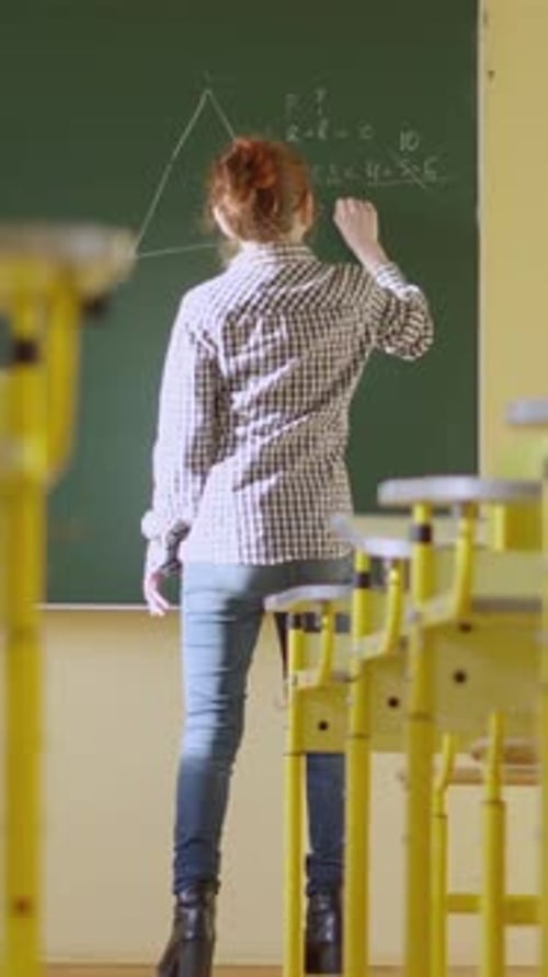 In a Classroom a Teacher Utilizes a Blackboard to Impart Geometry Lessons Aiding Students in