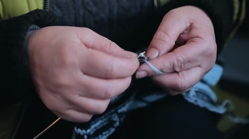 Close Up of Hands Knitting Blue and Grey Yarn