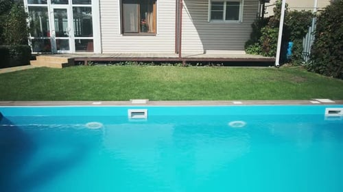 Skimmer and LED lighting in a blue pool in a country house. Clear blue water in the pool. Relax in t