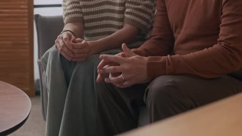 Hände einer liebenden Frau trösten Ehemann während der Eheberatungssitzung
