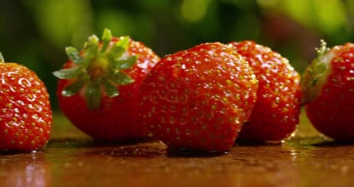 juicy strawberries scattered on a wooden table for the preparation of strawberry jam or juice.
co