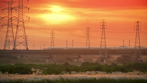 In der Abenddämmerung und bei Sonnenuntergang fährt ein Hochgeschwindigkeitszug über die Brücke.