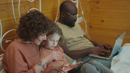 Family Relaxing with Technology Devices in Bed