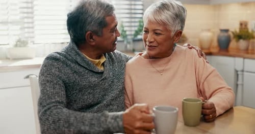 Affectionate Senior Couple Drinking Coffee at Home