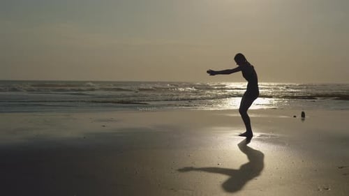 Woman Does Yoga Backbend on Beach at Sunrise