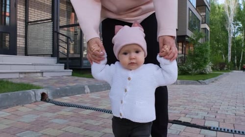 Infant learning to walk with support of adult