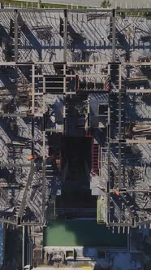Vertical Video of Residential Construction in Progress With Workers Installing Metal Beams and