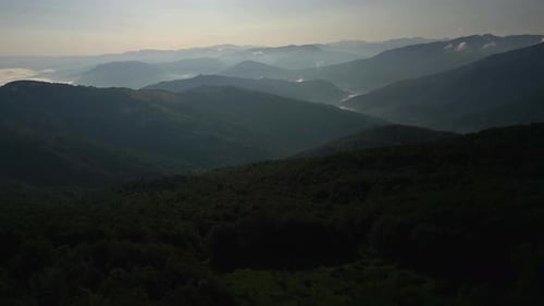 Aerial View of Morning Panorama of Mountains Stretching Into the Distance and Covered with Light Fog