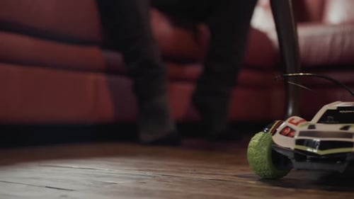 Small remote-controlled electric car in the living room of a house starting out of frame