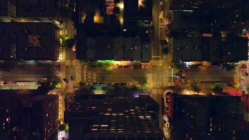 Well-lit streets of New York at night time. Traffic of metropolis from bird's eye view.