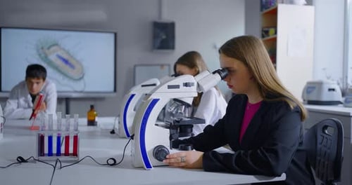 School Students Studying Biology In Classroom With Modern Equipment Teenagers Looking To Microscope