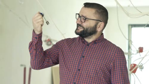 Erfolgreicher Hausbesitzer zeigt voller Freude die Schlüssel zu seiner neuen Wohnung