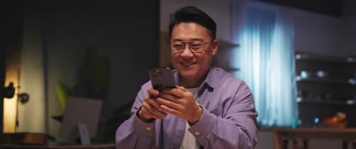 Smiling Man Using Smartphone in Modern Interior