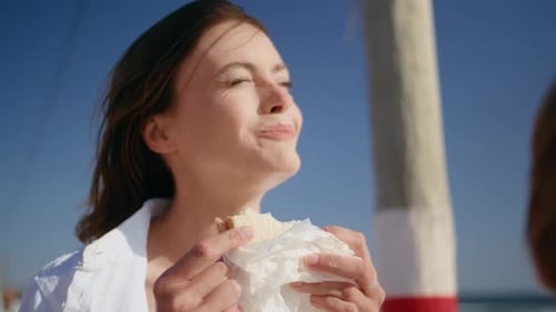 Woman and Child Eating Sandwiches on Beach