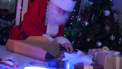 Santa Claus Wrapping Christmas Gifts at Home