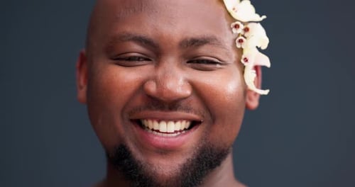 Flowers, self confidence and smile with face of black man in studio for acceptance