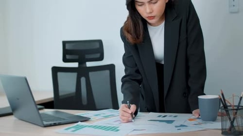 Woman Reviews Data in Bright Modern Office