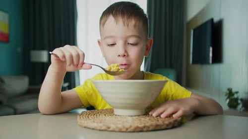 Portrait Little Hungry Child Cute Boy Sits at the Dinner Table Eats Corn Flakes with Milk with an