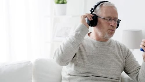 Senior Man Listening to Music with Headphones Indoors