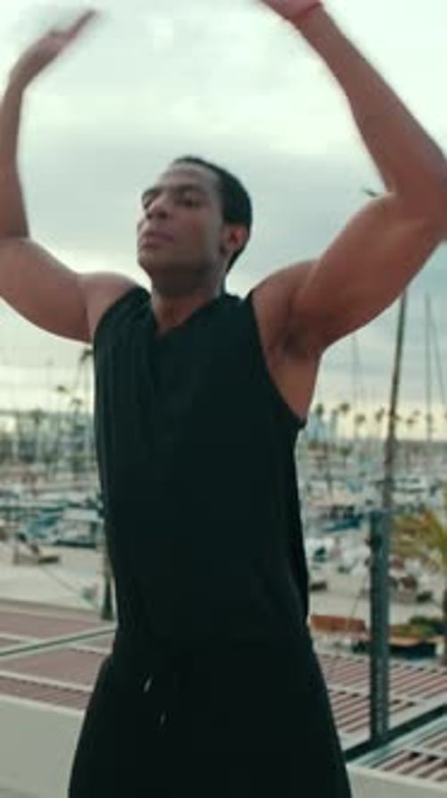 Vertical video, Man Doing Jumping Jacks at a Marina