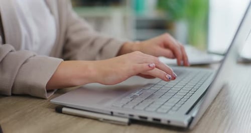 Woman Typing on Laptop in Office Setting