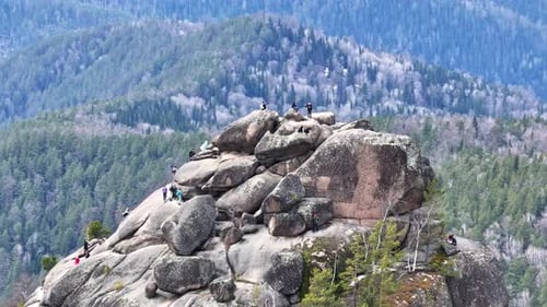 Explorers Climb Unique Rock Formation in the Scenic Mountains During Springtime Adventure