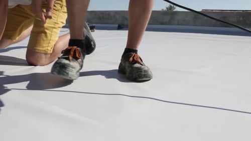 Roofers Use Heat Gun on Light Grey Roof