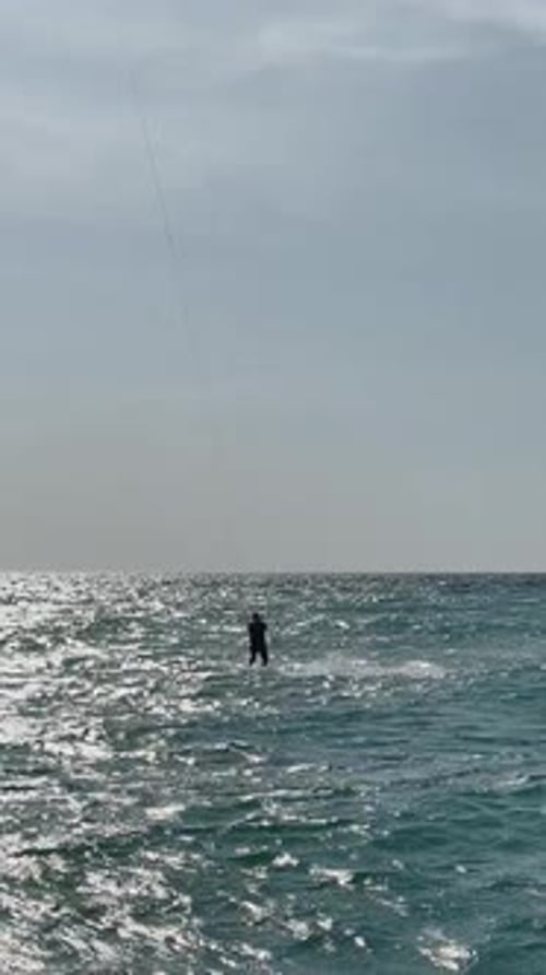 Man Kiteboarding on Sea Against Sky During Summer