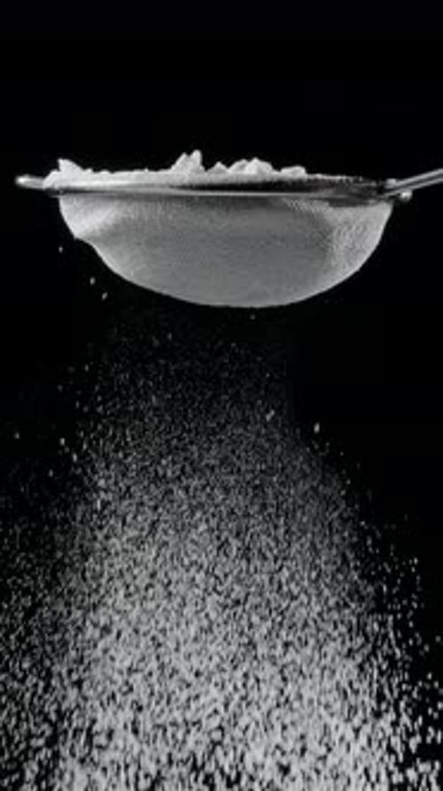 Sift icing sugar or powdered sugar through a sieve tool.
