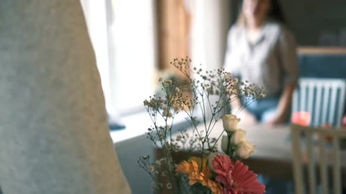 Man Giving Flowers to Woman at Home