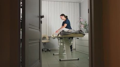 Doorway View of Beauty Expert Massaging Spa Guest Back