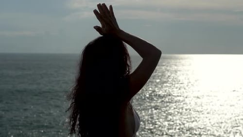 Silhouettierte Frau, die draußen in der Natur Meditation und Yoga durchführt