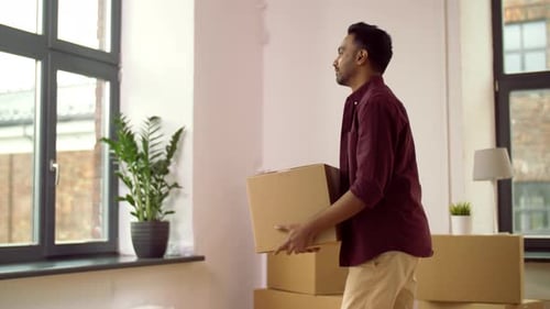Man Carries Moving Box in Bright Room