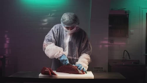 A Man Cook Cuts a Fresh Red Raw Fillet in a Butcher's Shop with a Kitchen Knife Slices Premium