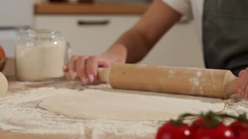 Rolling Pizza Dough With Rolling Pin in Kitchen