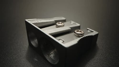 Dual-Blade Pencil Sharpener on Dark Surface – Cinematic Macro