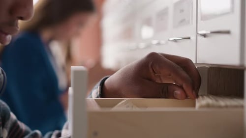 Hand of Man Looking for Library Card in Drawer