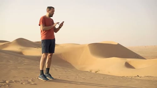 Man using phone in desert landscape