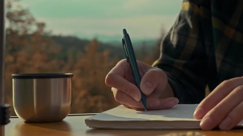 Writing in Notebook Outdoors with Coffee