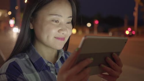 Young Asian Woman Using Smart Phone Tablet In the City Streets