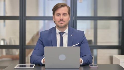 Man Working at Laptop Gives Thumbs Up